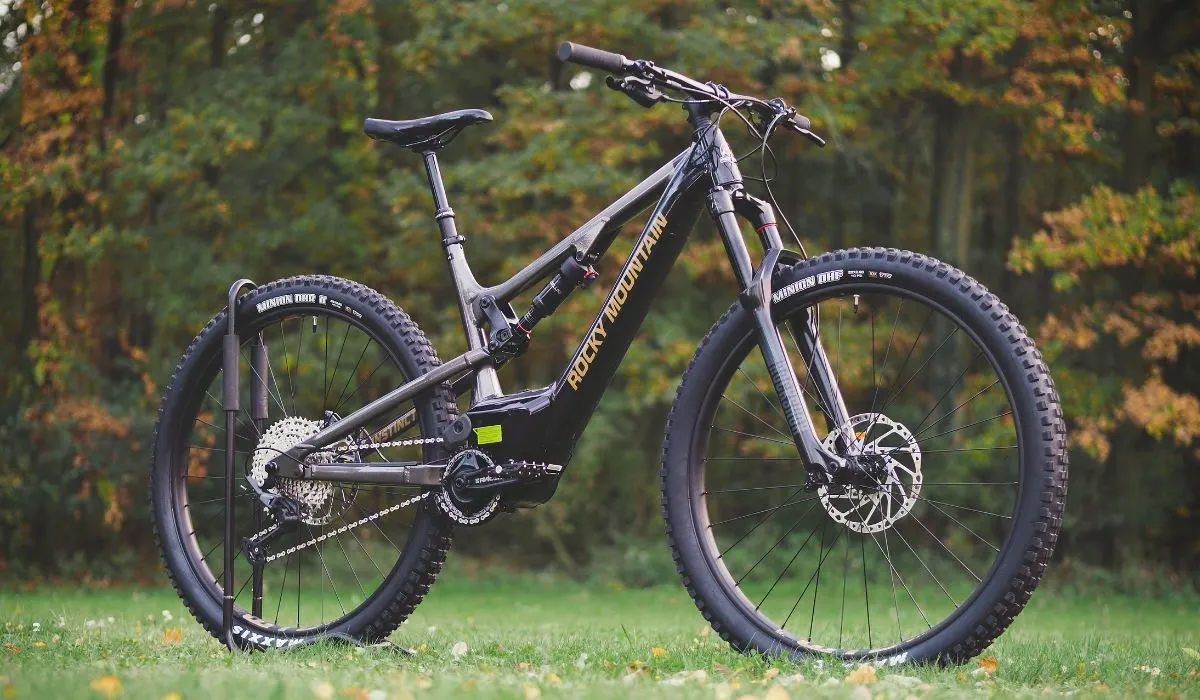 A black mountain bike in a wooded area.