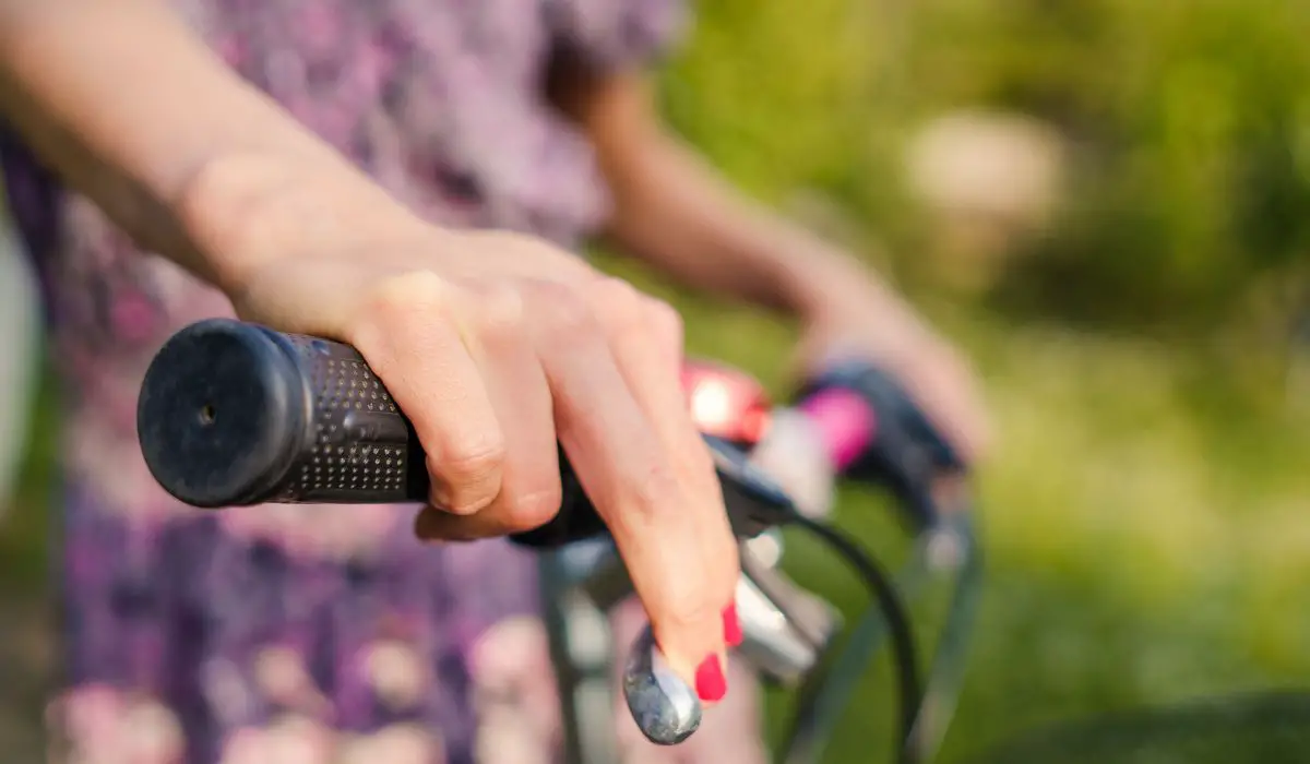 A hand on a bike handlebar.