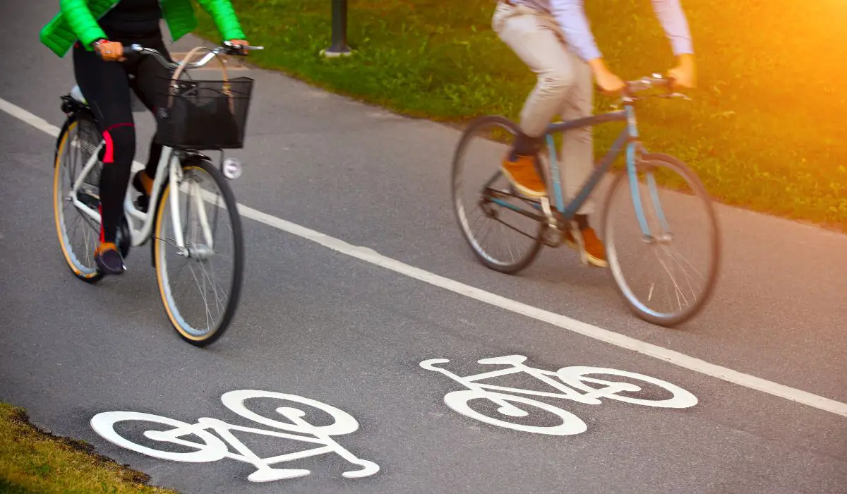 2 people riding bikes on a bike lane. 