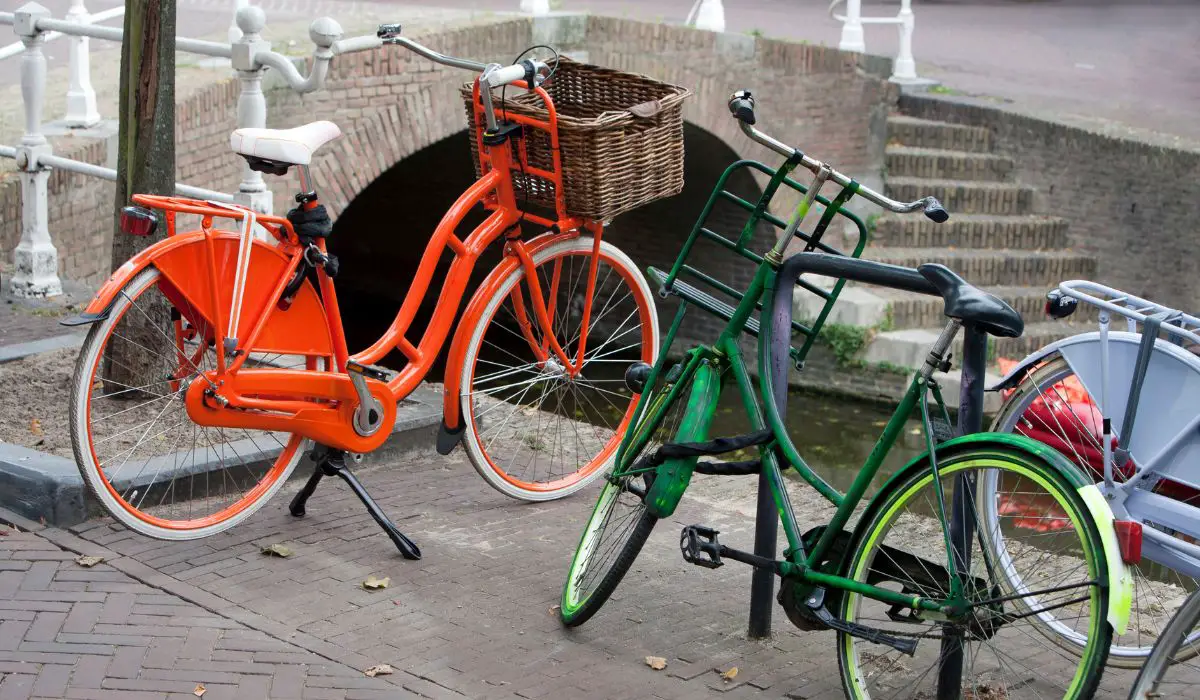 2 similar vintage looking bikes, one painted orange and one painted green. 