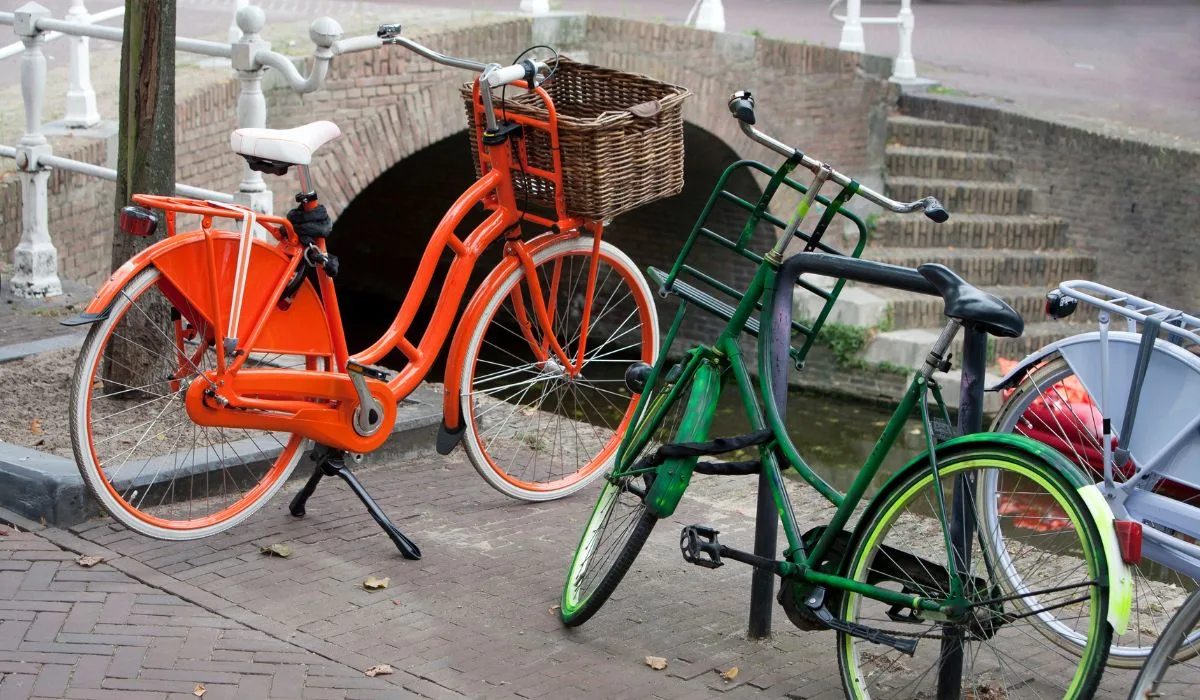 2 similar vintage looking bikes, one painted orange and one painted green. 