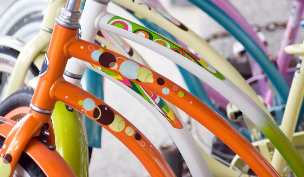 Bikes in a row of all different colors and unique designs on each, some with dots, some rainbows, some fading to other colors. 