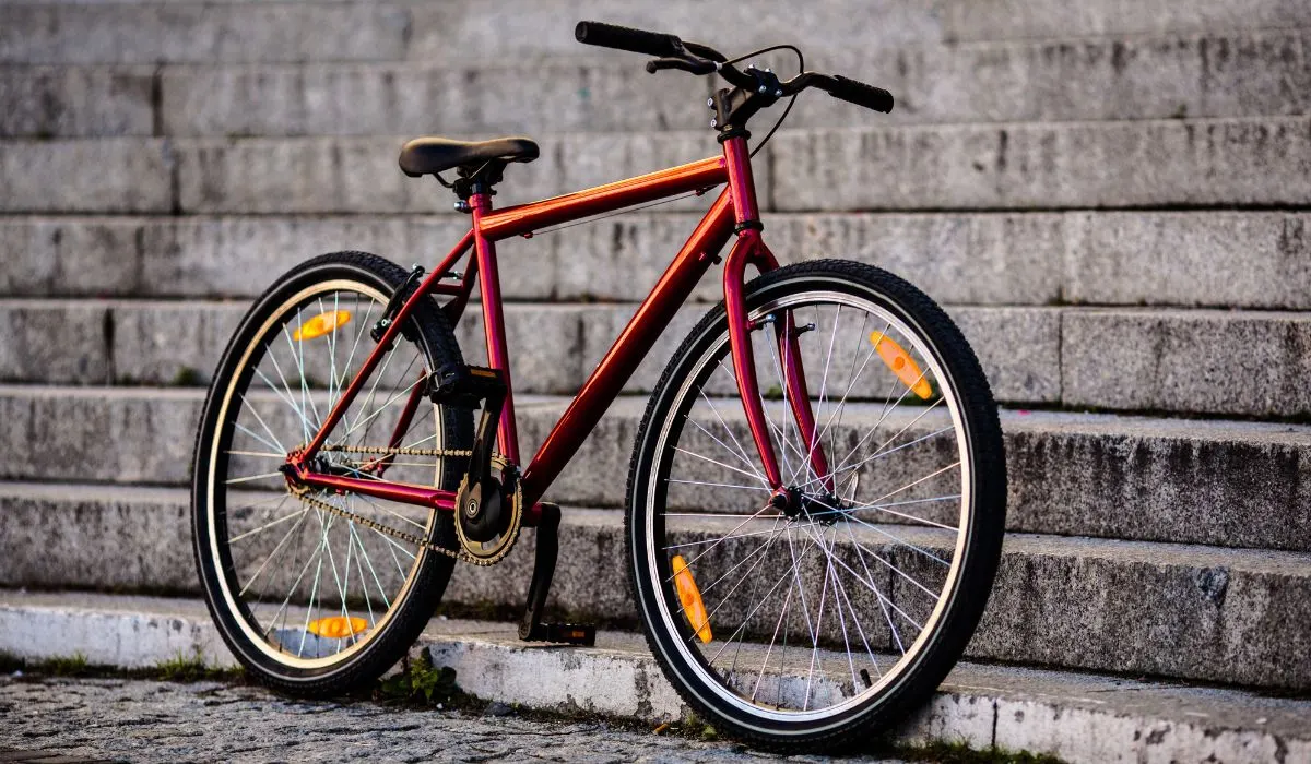 A bike with a really nice custom paint job with paint that is red/orange and iridescent.