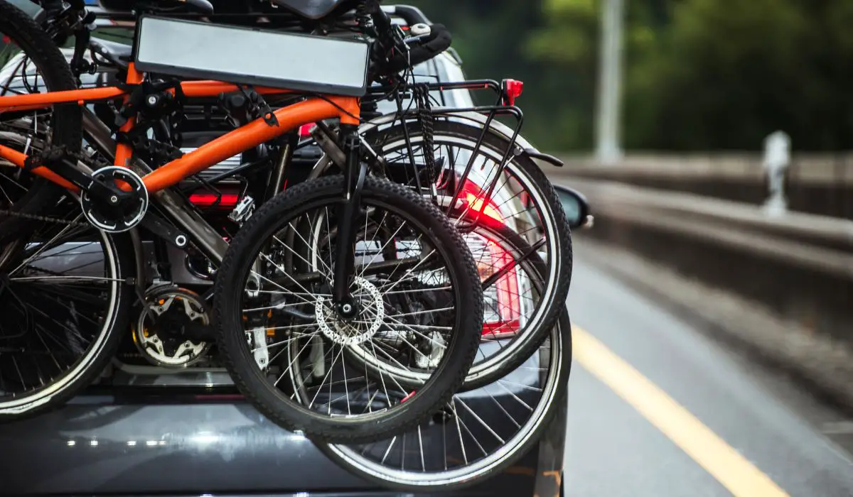 Bikes loaded onto a trunk bike rack on a sedan. 