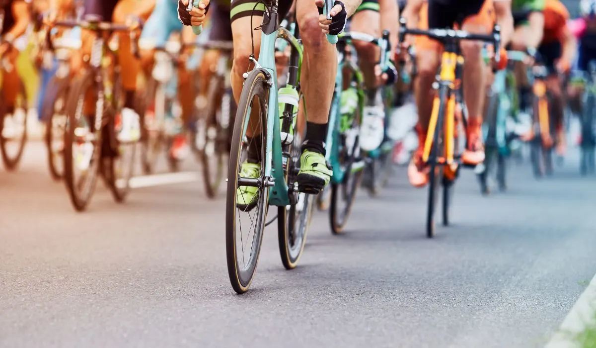 Wheel front view of many cyclists on road bikes. 