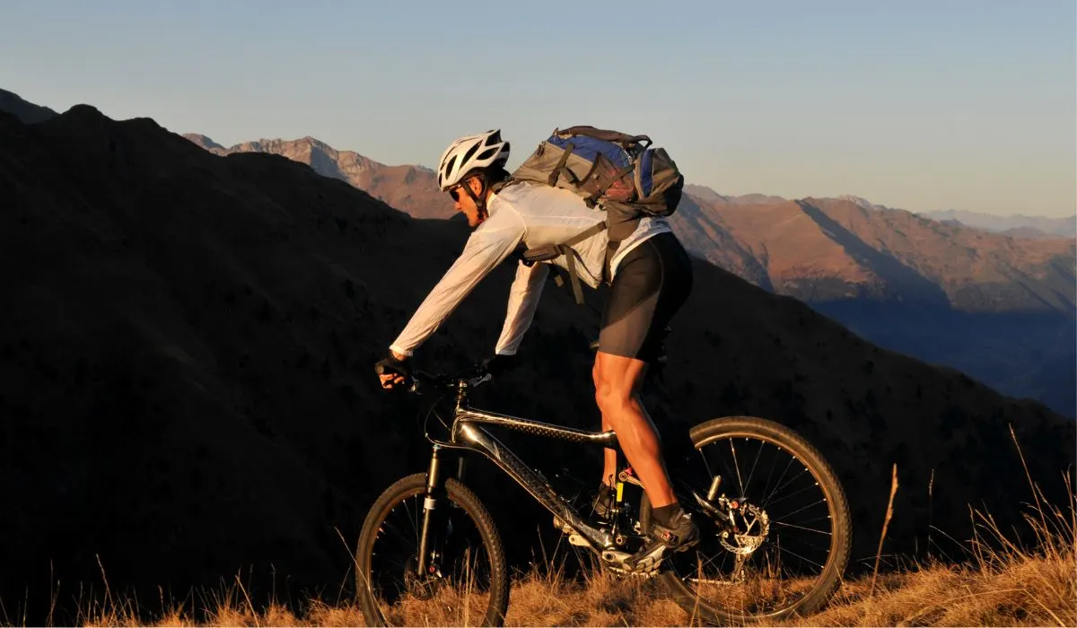 A person on a mountain bike with a backpack. 