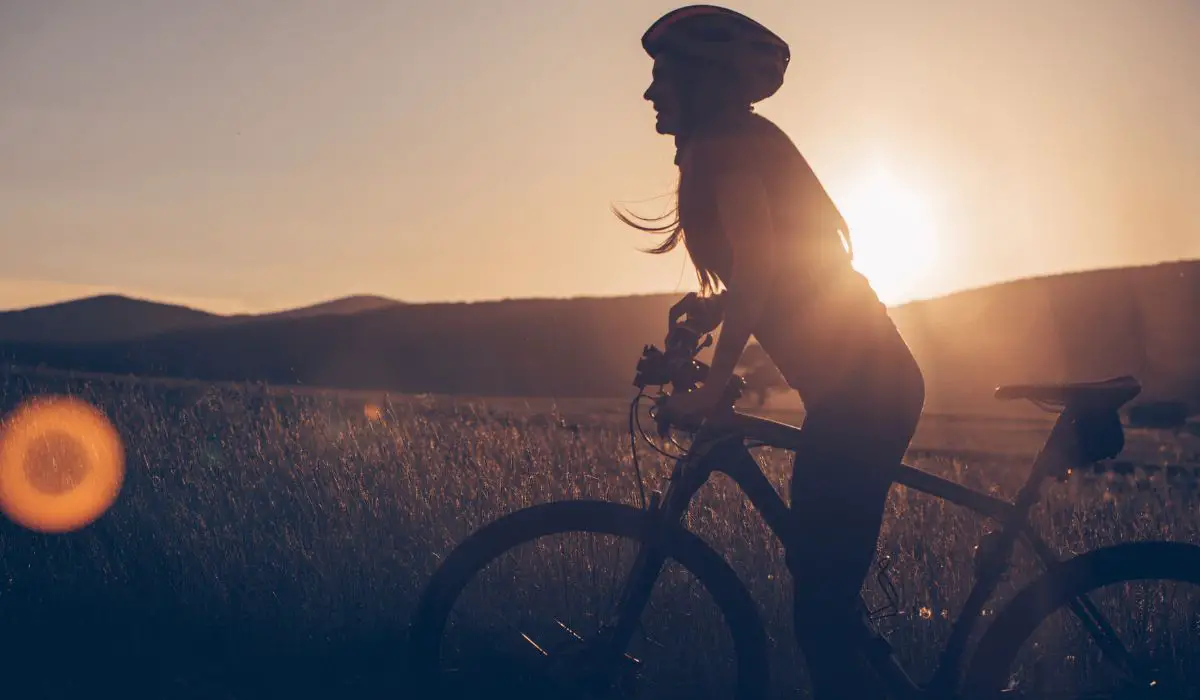 A cyclist pausing while the sun sets.