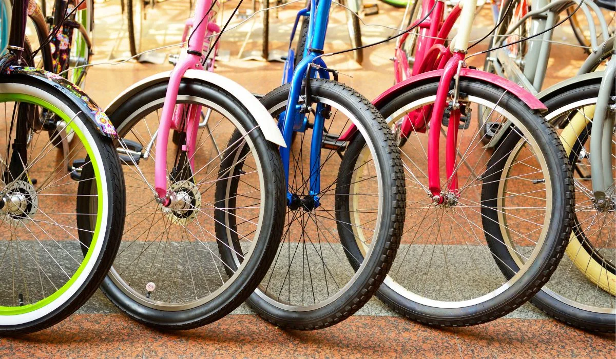 A line of parked bikes of different colors. 