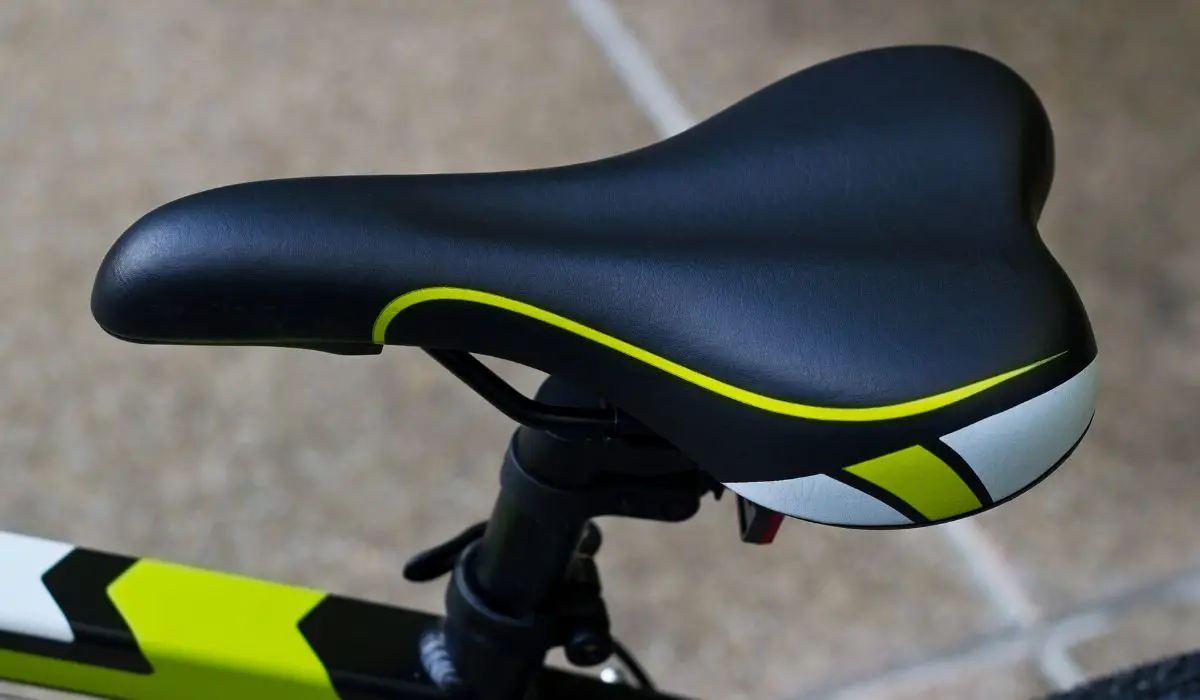 A black bike seat with bright green details. 