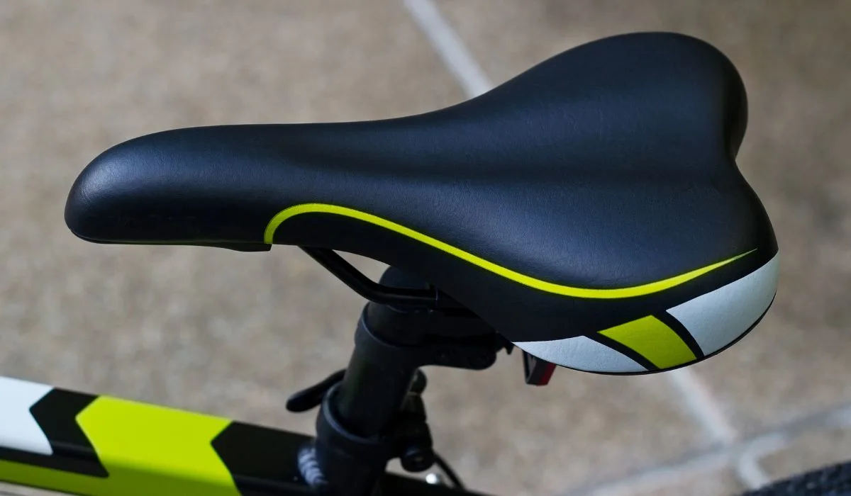 A black bike seat with bright green details.