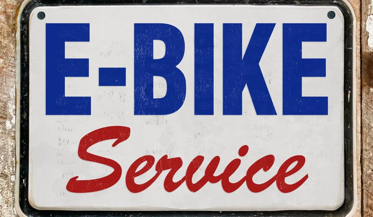 A sign that says E-bike service in blue and red with a white background. 