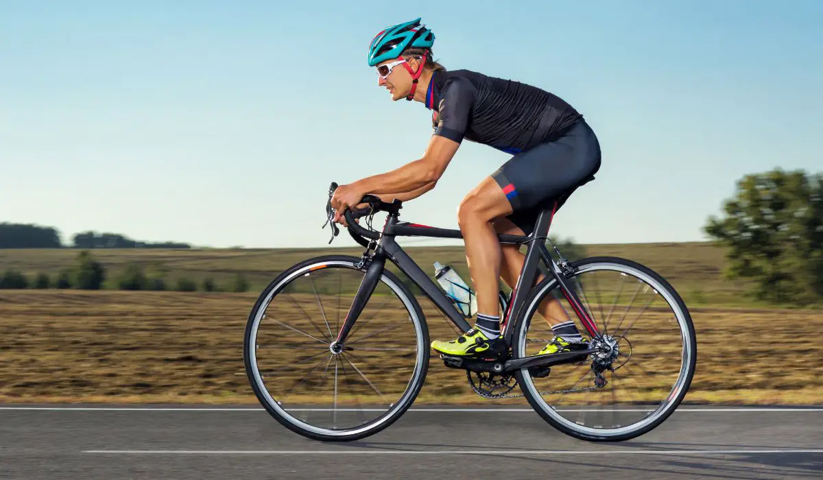 A man riding a road bike on a peaceful looking country road.