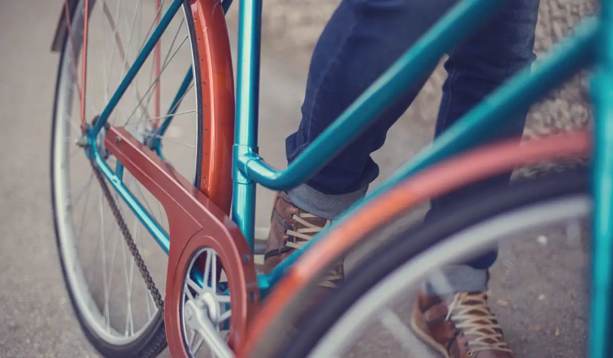 A retro looking bike frame close up, it's blue and orange rust paint adding to the look. 