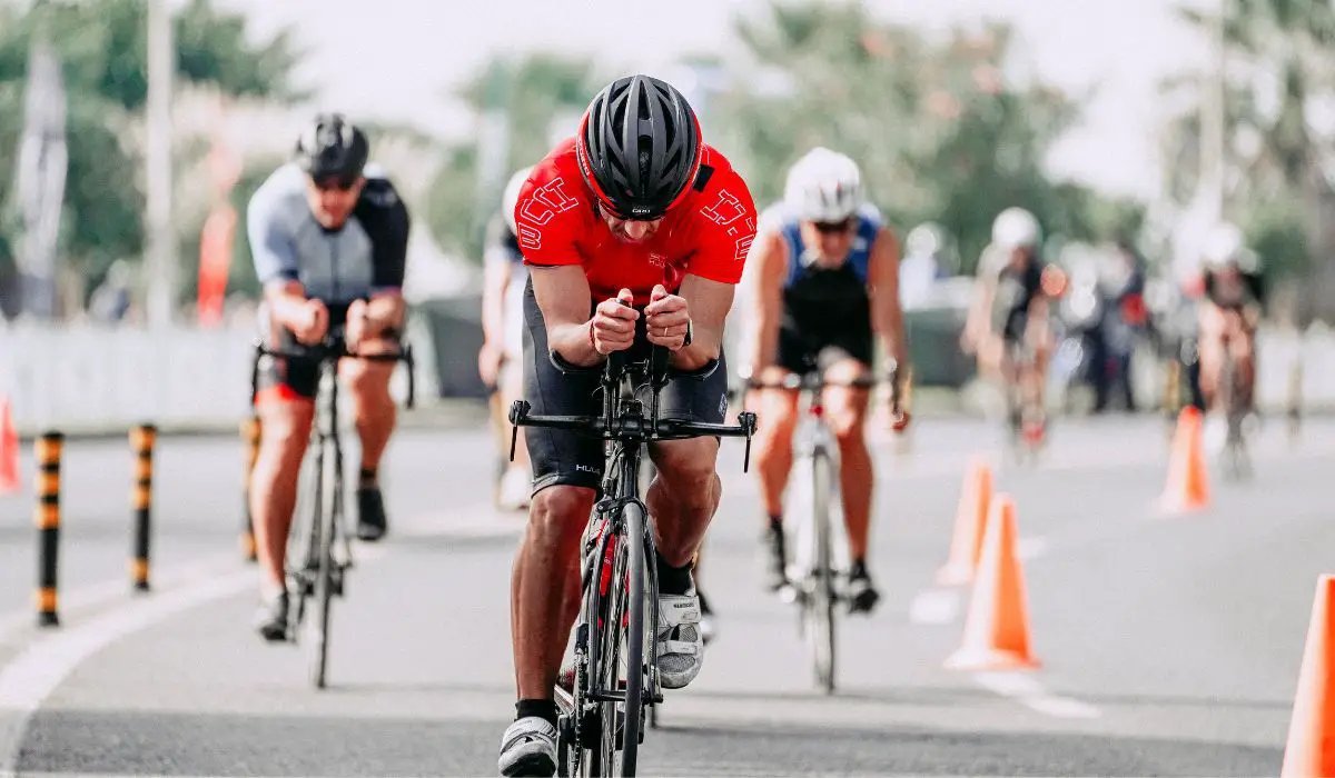 A road bike race showing several cyclists leaned over their low handlebars in an aerodynamic position. 