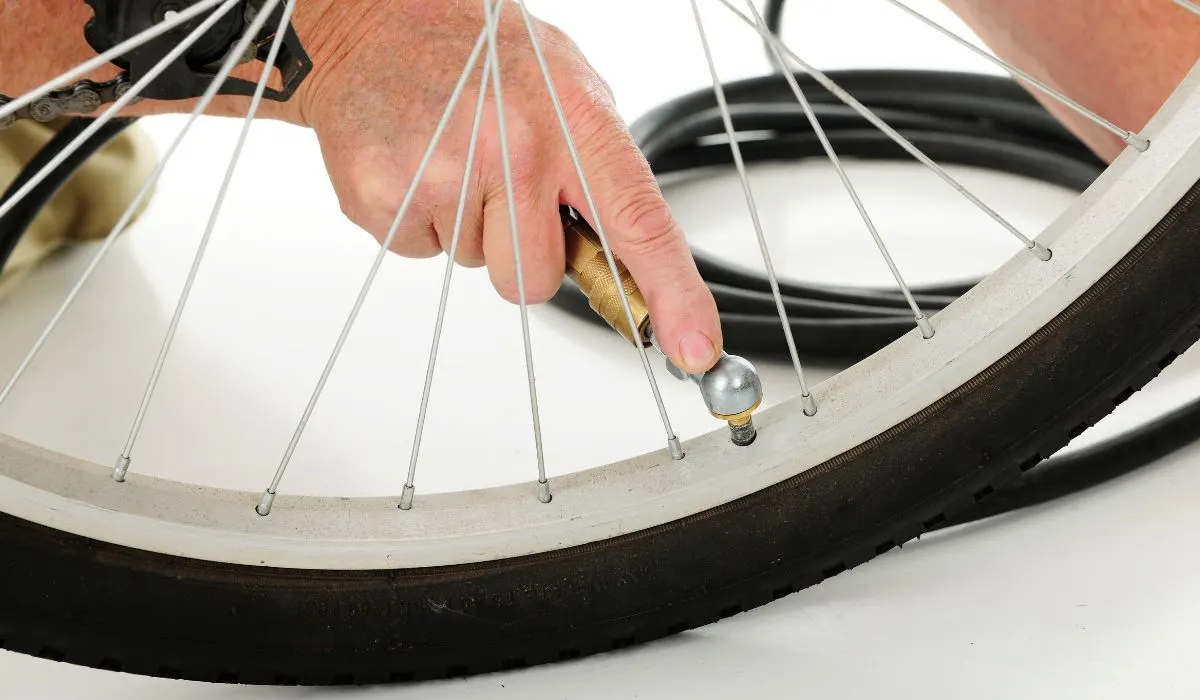A bike tire with a pump connected to the valve. 