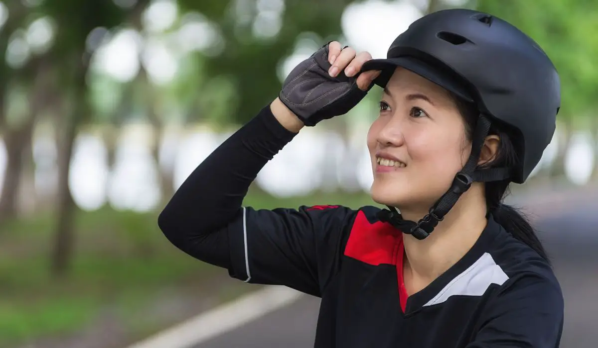 A woman wearing a bike helmet with a small visor. 
