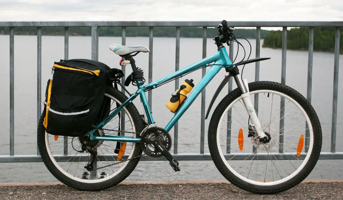 A bike with a  rack in the back holding a pannier bag on each side. 