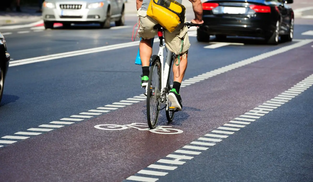A cyclist in a bike lane riding with the flow of traffic. 