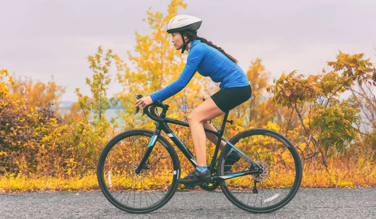 A woman in cycling clothes riding to work on a bike path. 