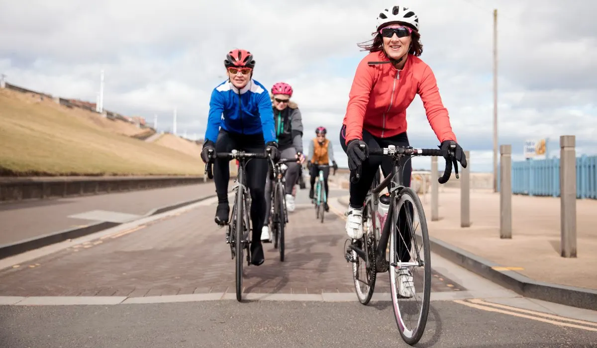 A group of people cycling with different jerseys on. 