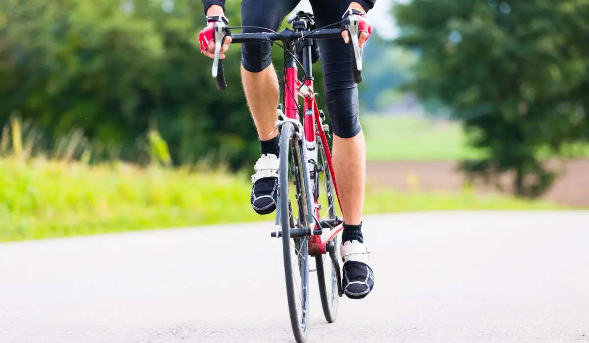 Front view of a cyclist on a road bike, wheels and legs. 