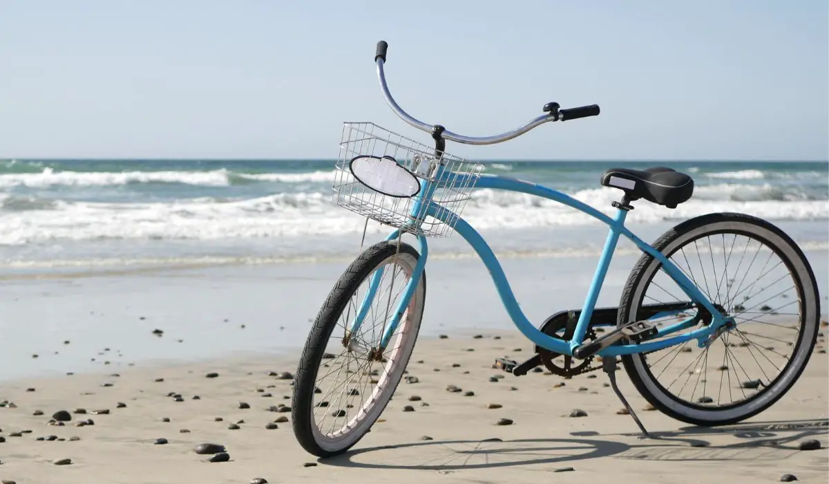 A blue cruiser bike on a beach. 