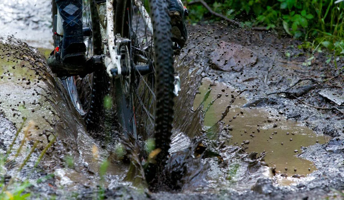 A bike splashing in a mud puddle.